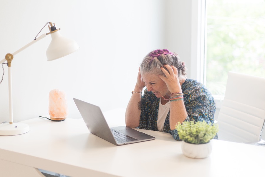 Person with brain fog struggling to focus at a laptop